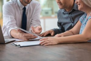 Advisor reviewing documents with couple at desk
