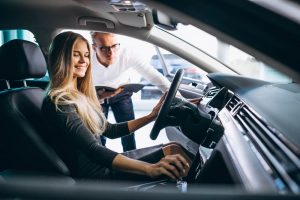 Woman sitting in car with advisor reviewing documents outside