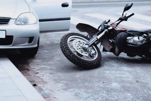 Motorcycle lying on road after collision with car