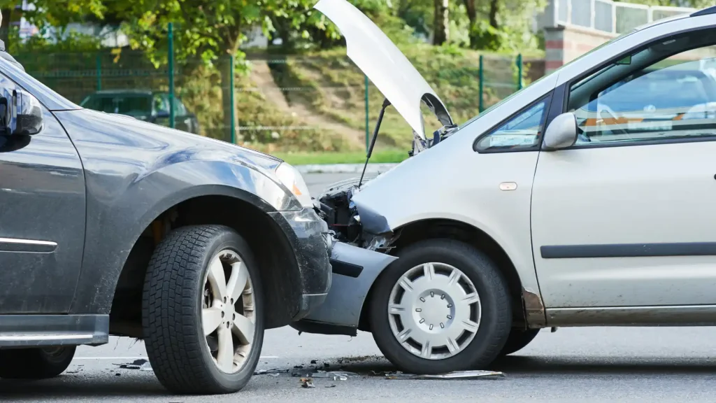Two cars involved in a front-end collision with visible damage.